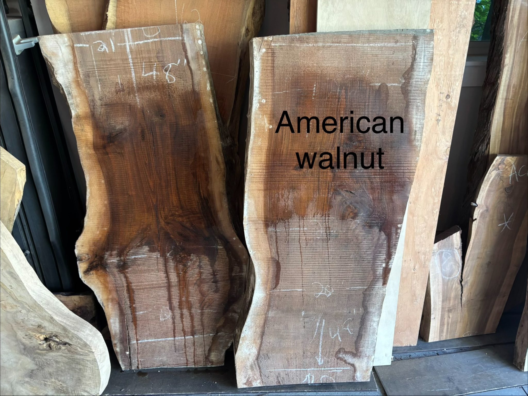 Two wooden boards leaning against wall, right board labeled "American walnut