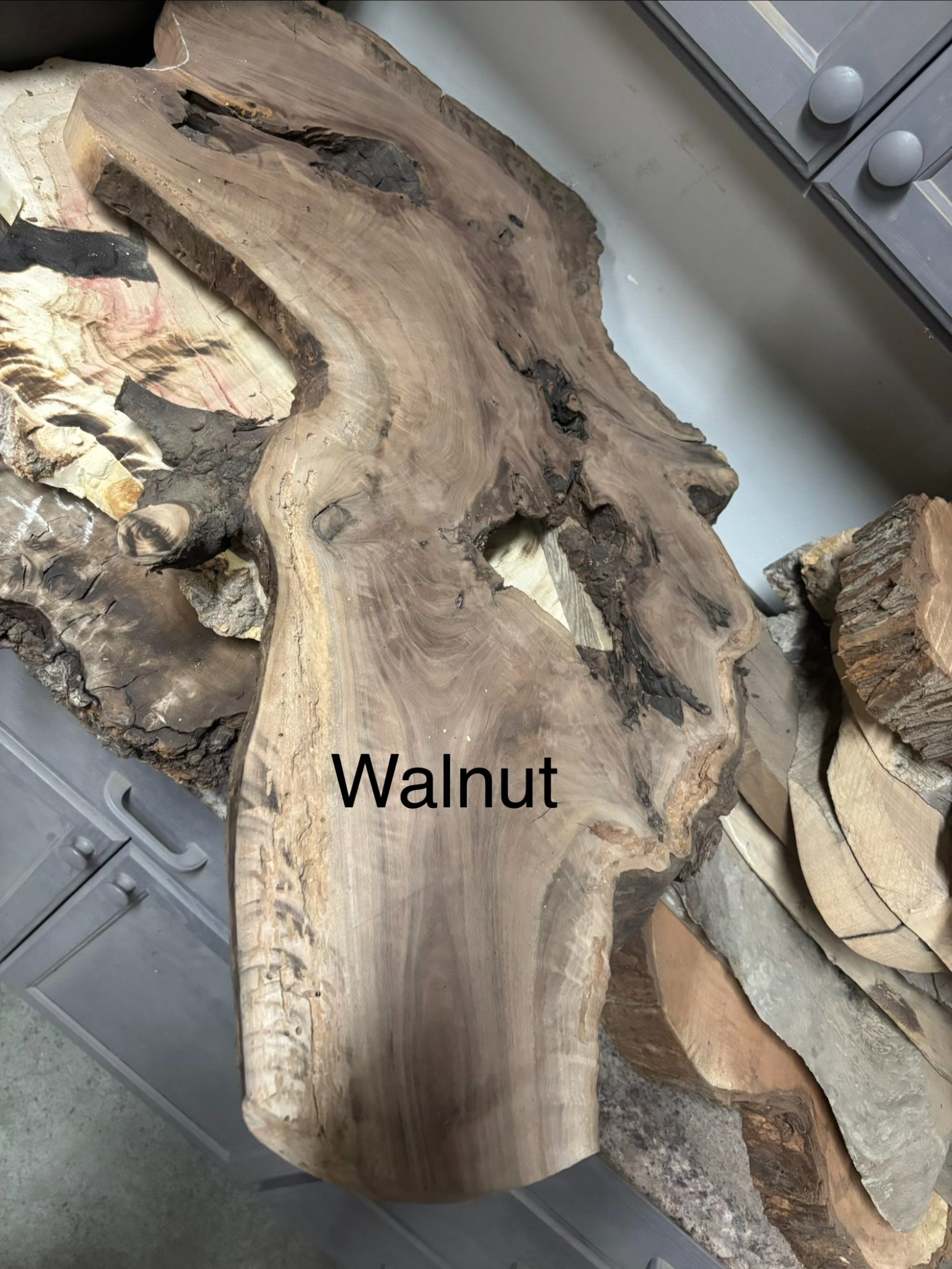Raw walnut wood slab with natural grain and knots displayed indoors